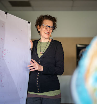 Jacquelyn Chase looks over some maps on Friday, October 30, 2020 in Chico, Calif. Chase has been working with Peter Hansen on research that shows where former Paradise residents went after their town was incinerated in the Camp Fire in 2018. (Jason Halley/University Photographer/CSU, Chico)